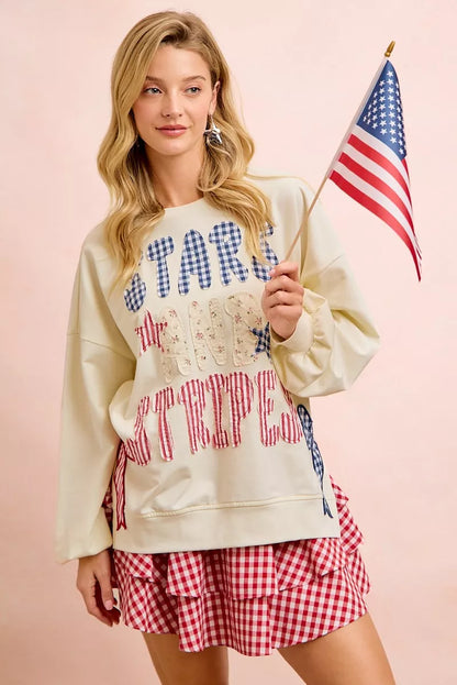 Cream sweatshirt with 4th of July stars and stripes patches from BiBi by Trendsi, featuring patriotic star and flag designs.