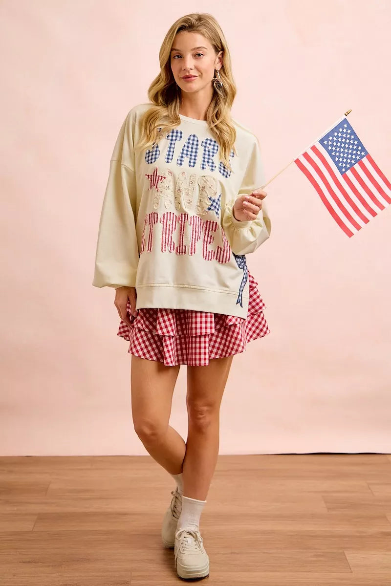 Cream sweatshirt by Trendsi with 4th of July stars and stripes patches, featuring patriotic red, white, and blue design.