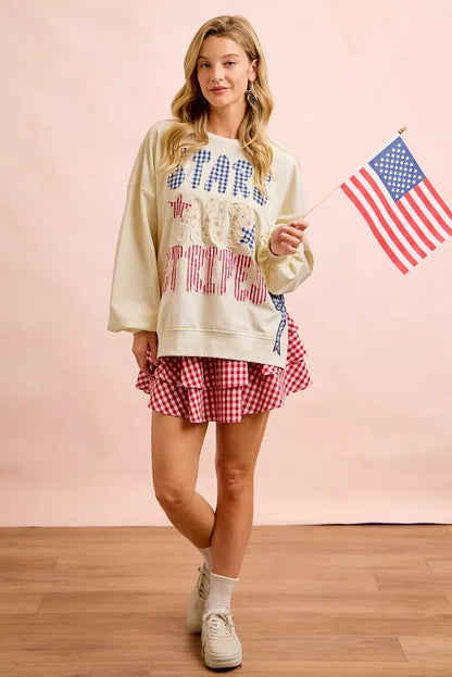 Cream sweatshirt by Trendsi with 4th of July stars and stripes patches, featuring patriotic red, white, and blue design.