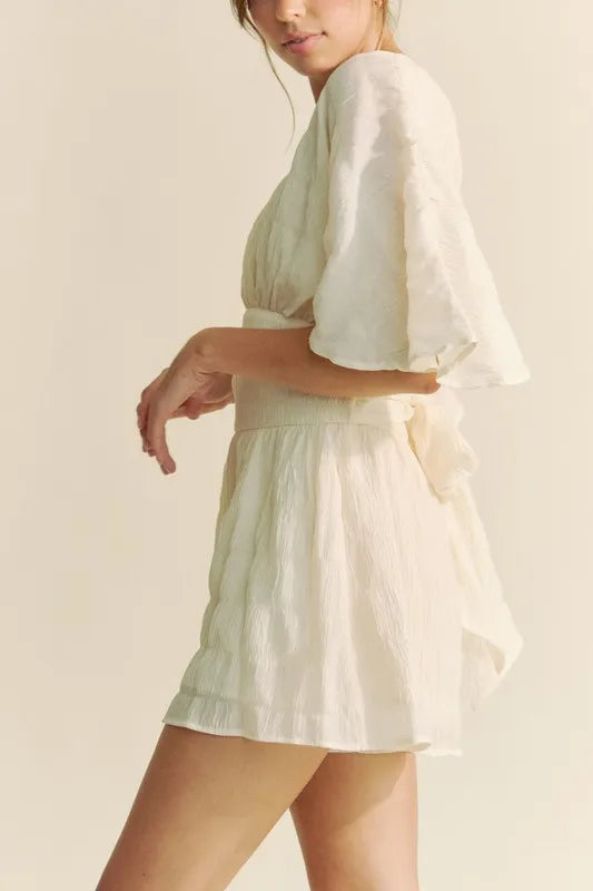 Cream Davi & Dani batwing sleeve waist belt romper with a relaxed fit, stylish design, and adjustable waist belt for a chic look.