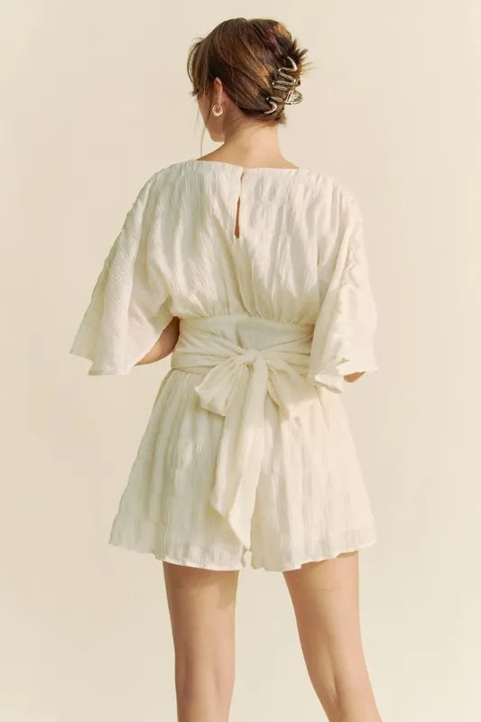Cream Davi & Dani Batwing Sleeve Waist Belt Romper by Trendsi featuring a relaxed fit and waist belt, perfect for casual wear.