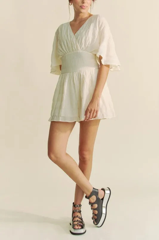 Cream Davi & Dani batwing sleeve waist belt romper by Trendsi, featuring flowy sleeves and a fitted waist for a stylish look.