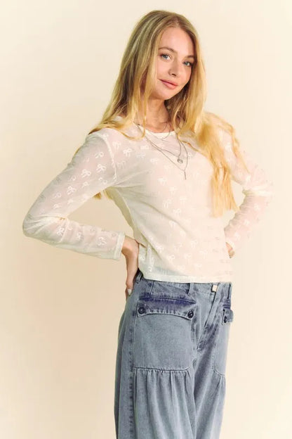 Cream Davi & Dani Bow Mesh round neck long sleeve top from Trendsi, featuring a stylish mesh fabric and bow detail at the neckline.