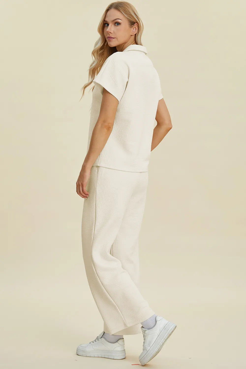 Cream-colored Trendsi Double Take short sleeve top and pants set featuring a collared neck and relaxed fit, stylish and comfortable.