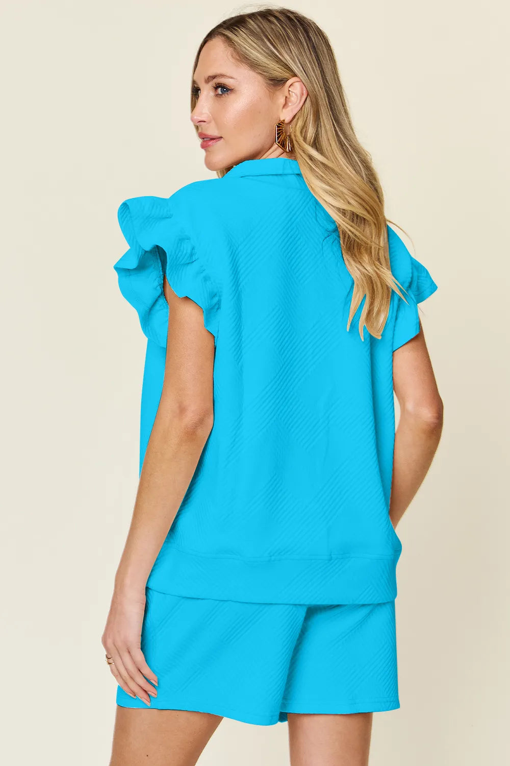 Cream-colored Trendsi double take full size textured flounce sleeve top with matching drawstring shorts set, casual and stylish.