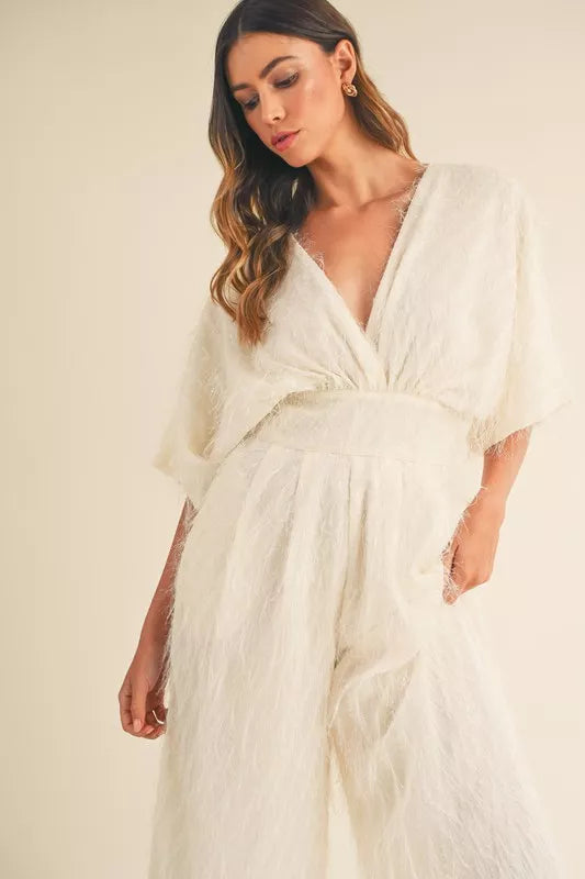 Cream MABLE fluffy deep V-neck wide-leg jumpsuit by Trendsi, featuring a soft fabric and stylish fit, shown on a model.
