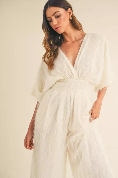 Cream MABLE fluffy deep V-neck wide-leg jumpsuit by Trendsi, featuring a soft fabric and stylish fit, shown on a model.