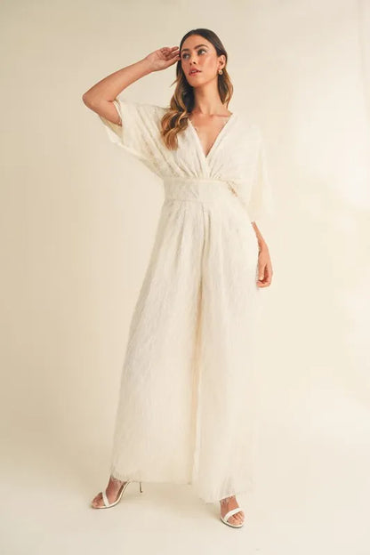 Cream MABLE Fluffy Deep V Neck Wide Leg Jumpsuit by Trendsi, featuring soft fabric and stylish wide-leg design.