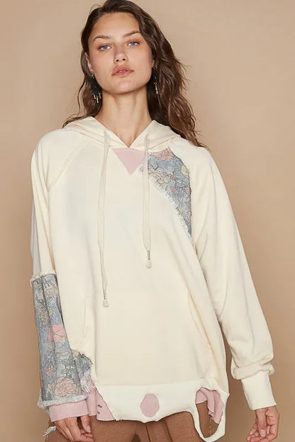 Cream floral patchwork distressed drawstring hoodie by Trendsi featuring a casual, comfortable design with floral accents.