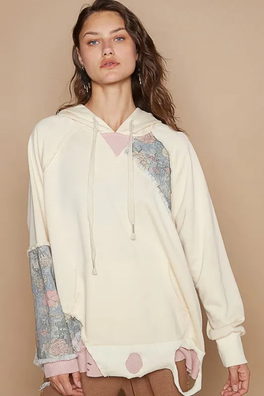 Cream floral patchwork distressed drawstring hoodie by Trendsi featuring a casual, comfortable design with floral accents.