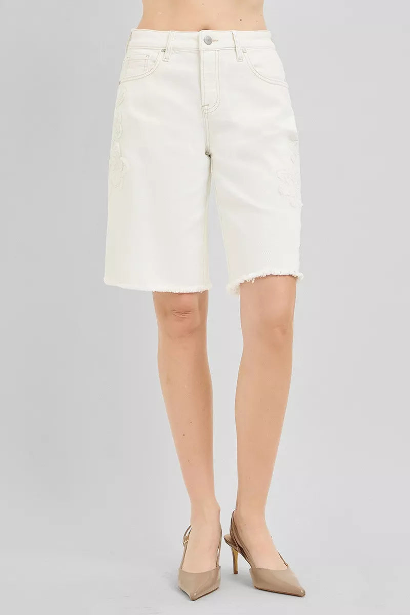 Cream-colored RISEN slouchy relaxed floral embroidered Bermuda denim shorts with distressed details, casual summer fashion.