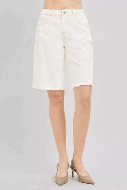 Cream-colored RISEN slouchy relaxed floral embroidered Bermuda denim shorts with distressed details, casual summer fashion.