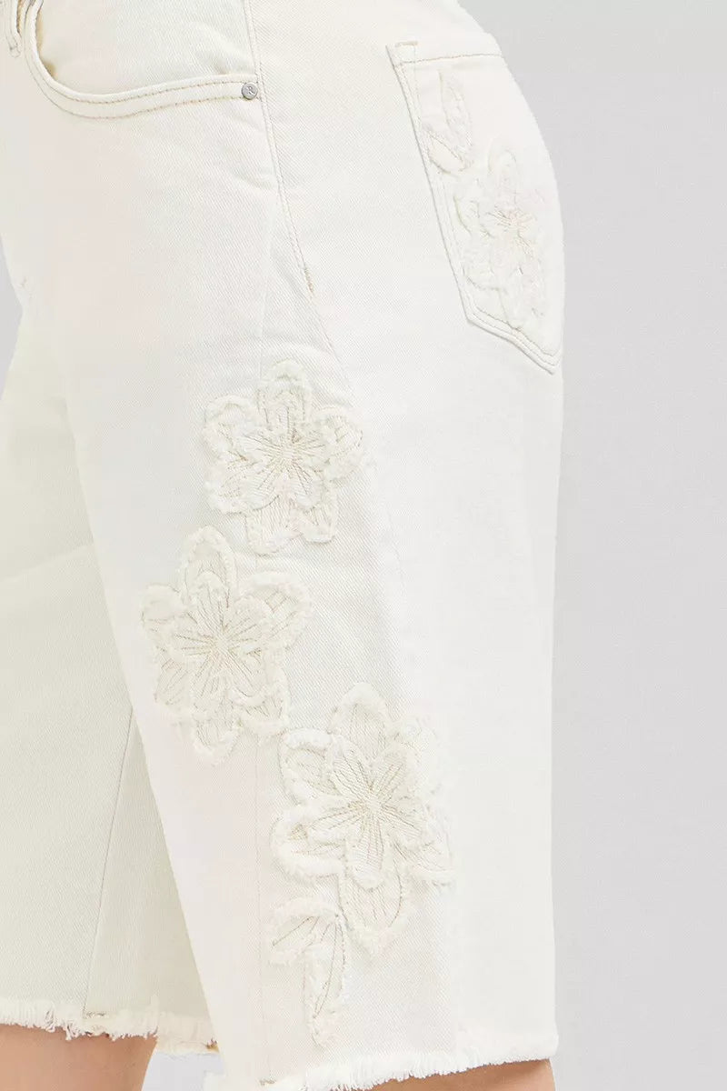 Cream-colored RISEN slouchy relaxed floral embroidered Bermuda denim shorts with distressed details, casual summer denim shorts for women.