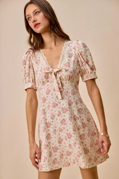 Cream floral lace-trimmed short sleeve mini dress by Trendsi, featuring a fitted silhouette and delicate lace details.