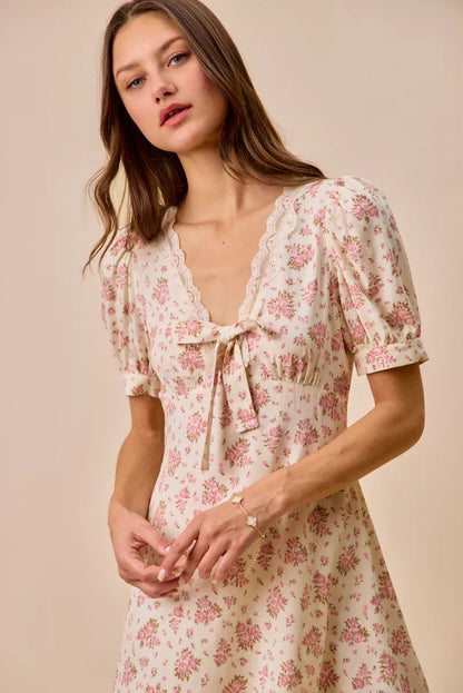 Cream floral lace-trimmed short sleeve mini dress by Trendsi, featuring a fitted silhouette and delicate lace details.