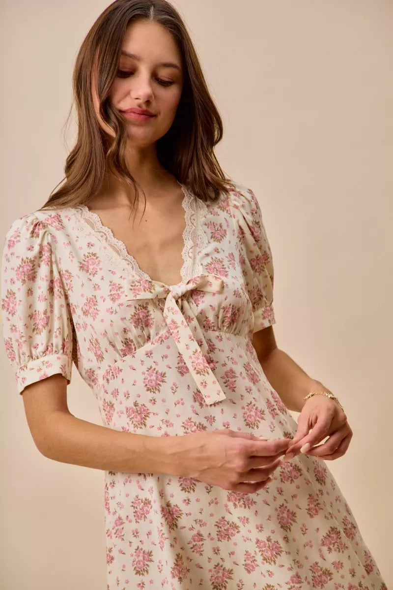 Cream floral lace-trimmed short sleeve mini dress by Trendsi, featuring a fitted silhouette and delicate lace details.