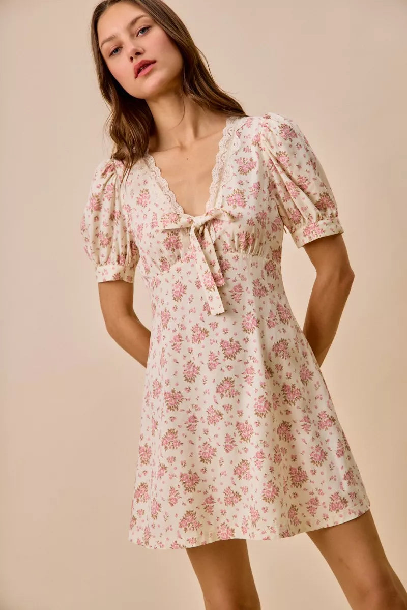 Cream floral lace-trimmed short sleeve mini dress by Trendsi, featuring delicate lace details and a fitted silhouette.