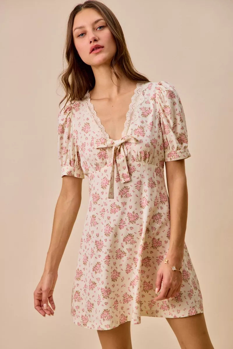 Cream floral lace trimmed short sleeve mini dress by Trendsi, featuring delicate lace details and a fitted silhouette.