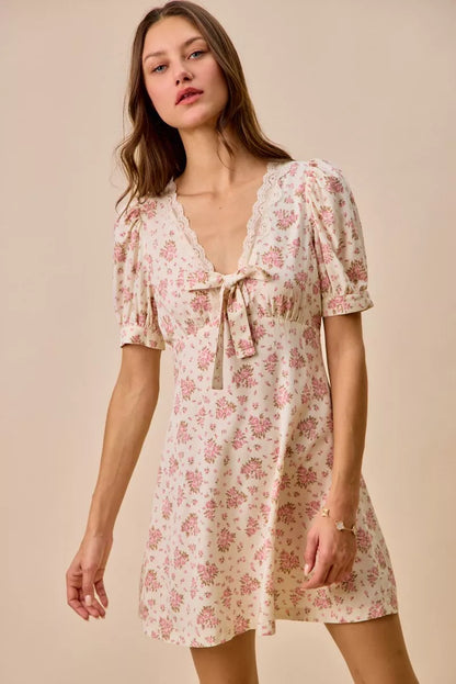 Cream floral lace trimmed short sleeve mini dress by Trendsi, featuring delicate lace details and a fitted silhouette.