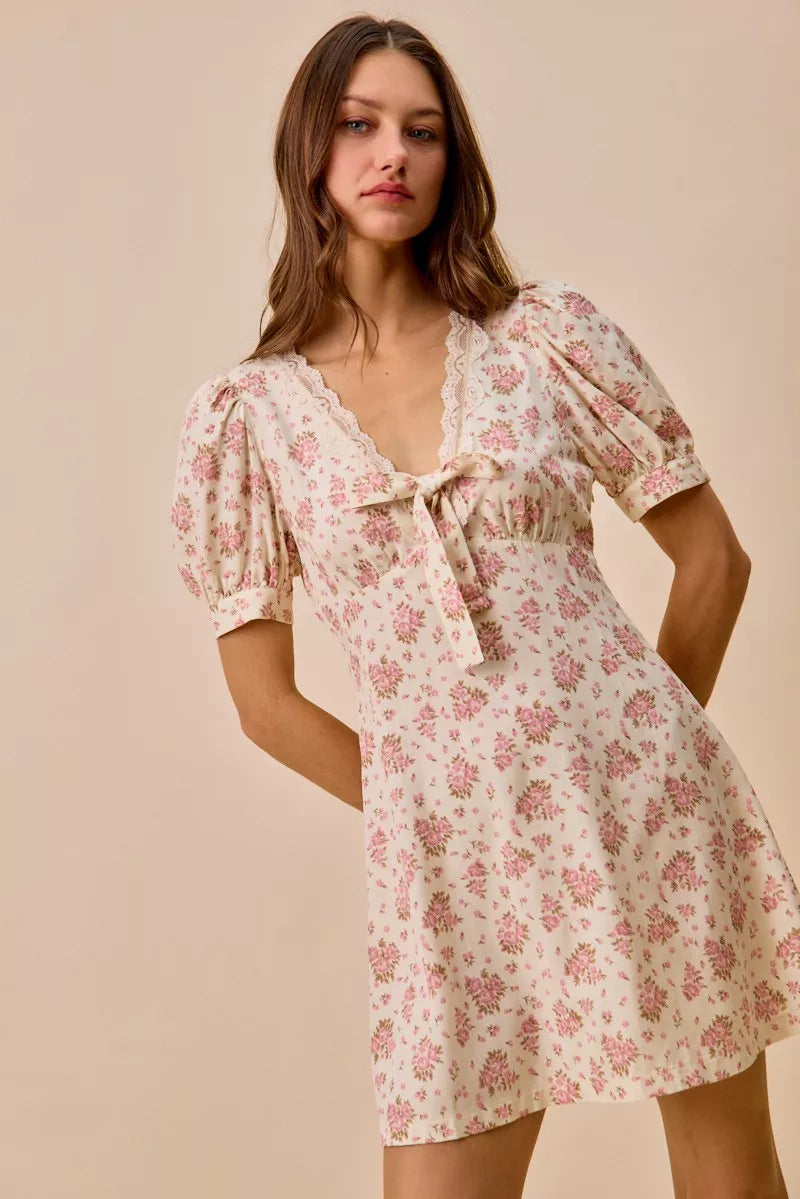 Cream floral lace-trimmed short sleeve mini dress by Trendsi, featuring a fitted silhouette and delicate lace details.