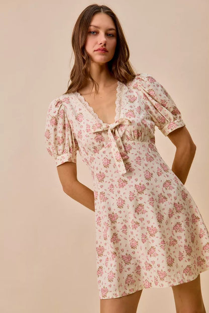 Cream floral lace-trimmed short sleeve mini dress by Trendsi, featuring a fitted silhouette and delicate lace details.