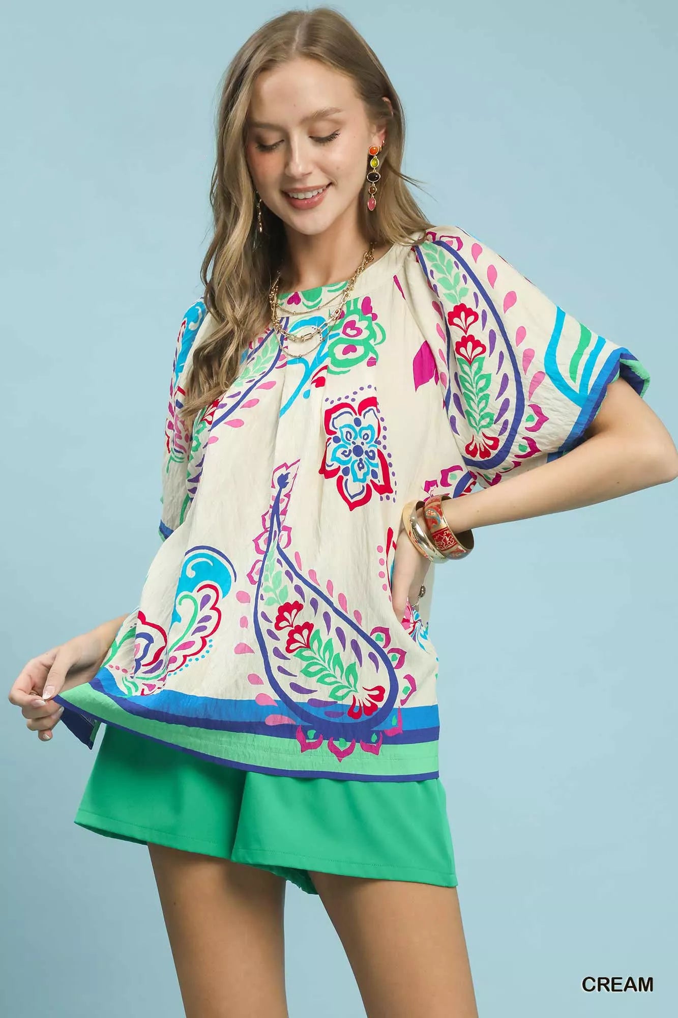 Cream Umgee border print puff sleeve blouse with ruffled accents and relaxed fit, styled with a feminine and trendy look.
