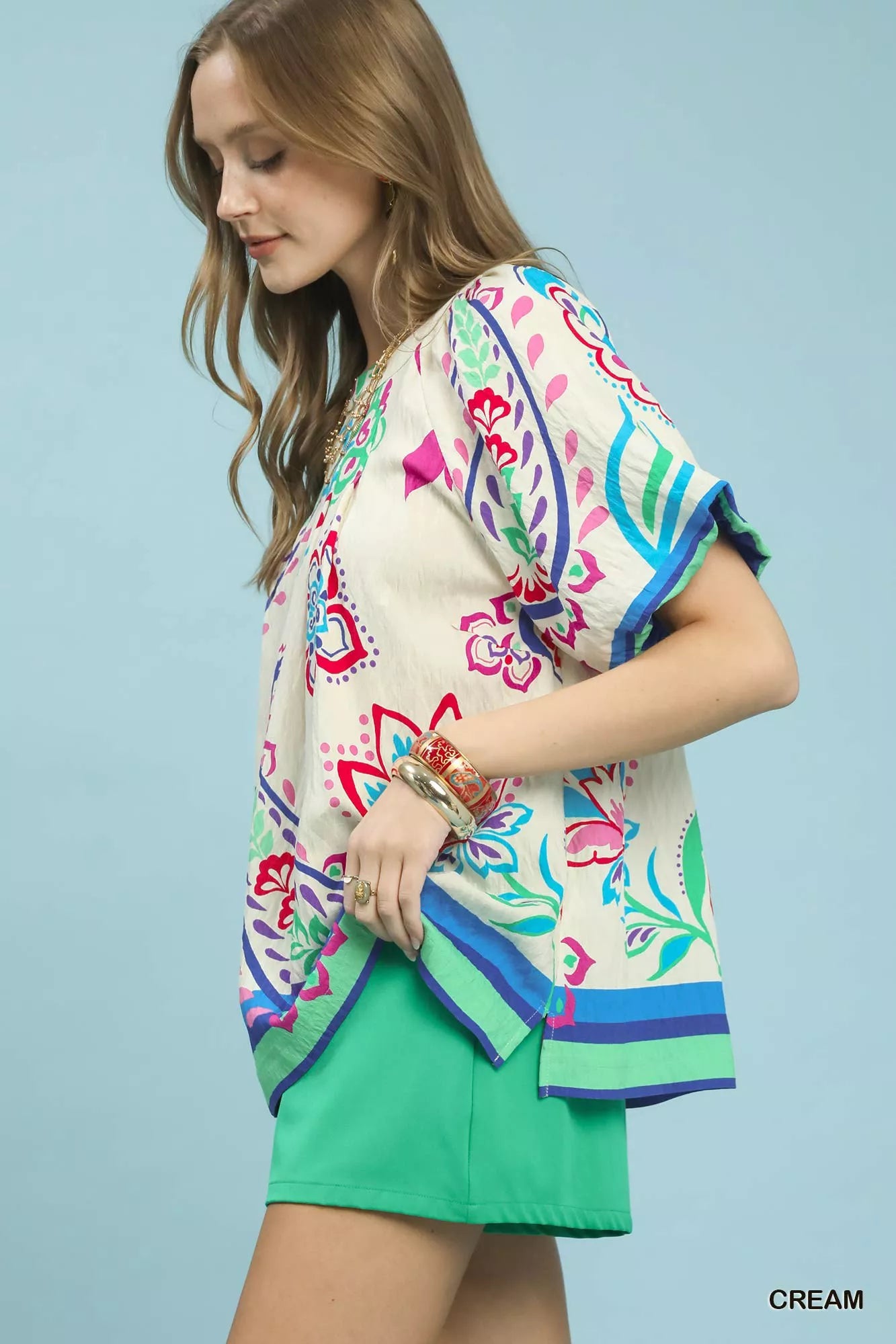 Cream Umgee border print puff sleeve blouse with ruffled details, featuring a relaxed fit and floral pattern.