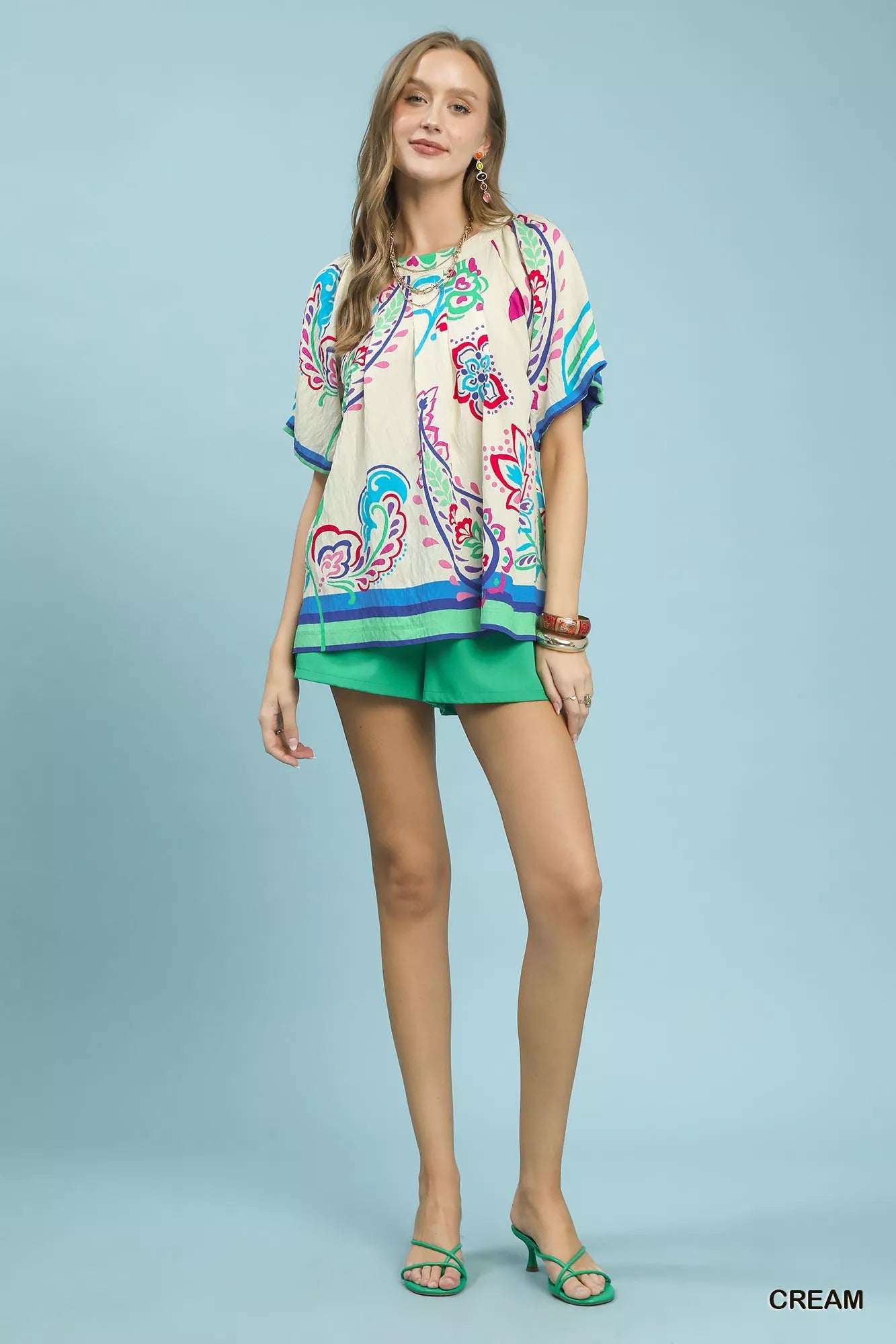 Cream Umgee border print puff sleeve blouse with ruffled details, showcased on a model with a relaxed, boho-inspired style.