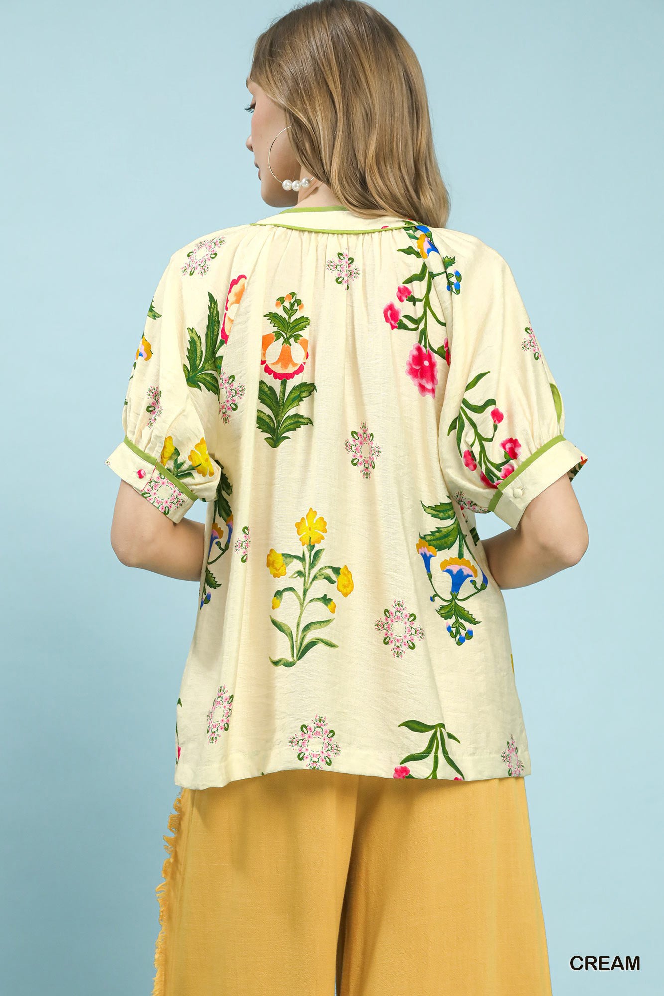 Cream Umgee botanical print blouse with contrast trim and button front, featuring a stylish and feminine design.