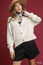 Cream Umgee button-front V-neck knit cardigan with long sleeves and ribbed cuffs, styled for a casual look.