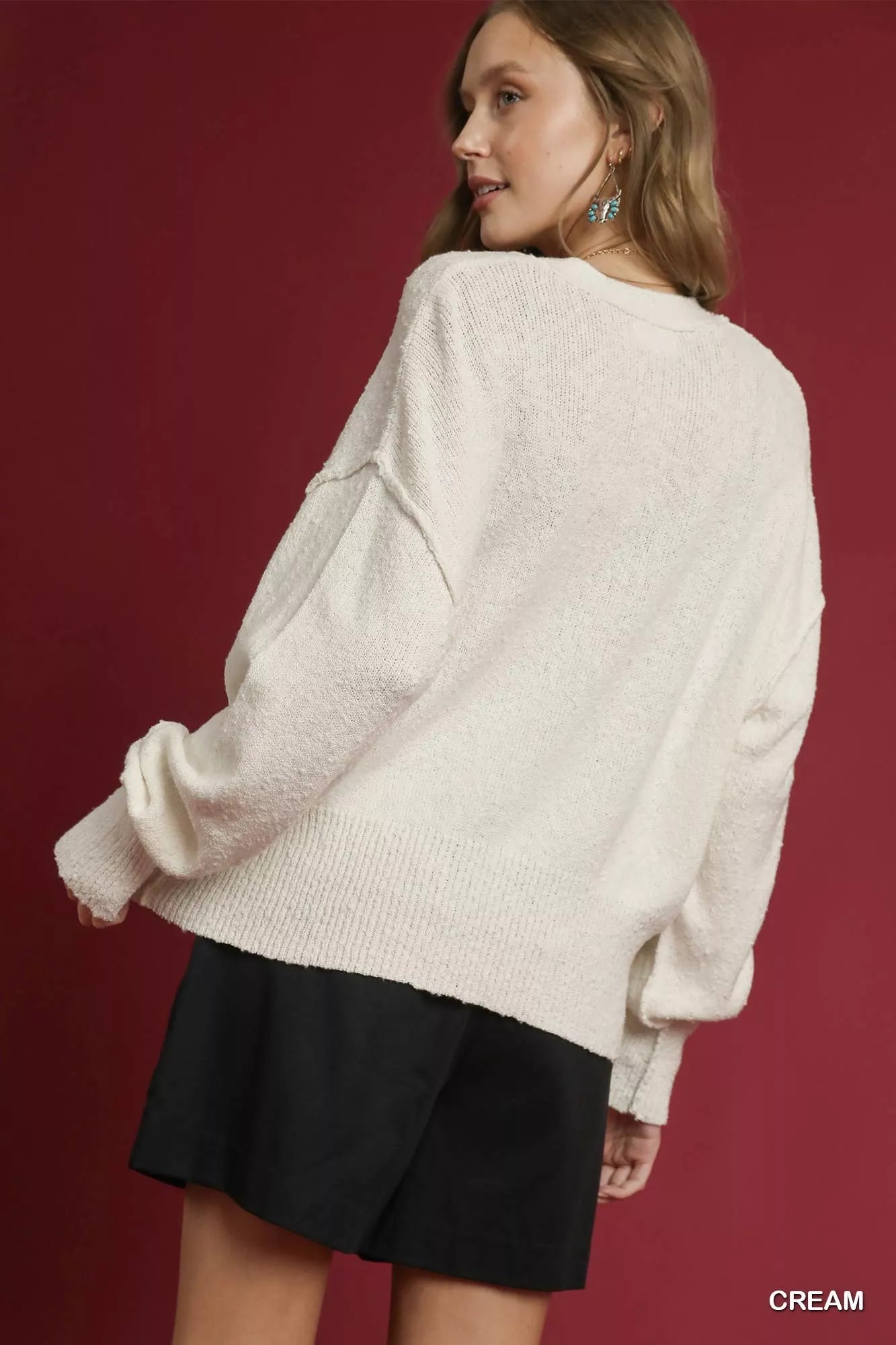 Cream Umgee button-front V-neck knit cardigan with long sleeves and ribbed cuffs, styled for a cozy, casual look.