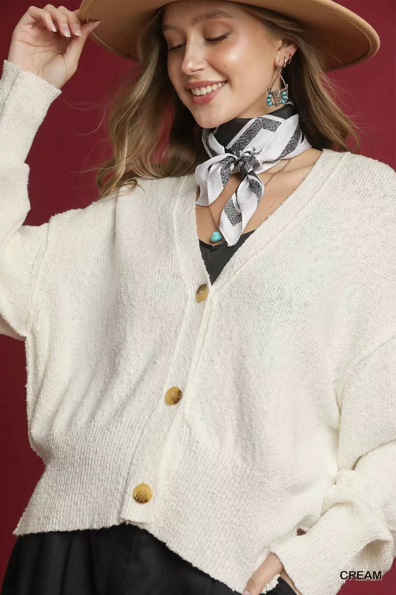 Cream Umgee button-front V-neck knit cardigan with long sleeves and ribbed trim, styled casually.