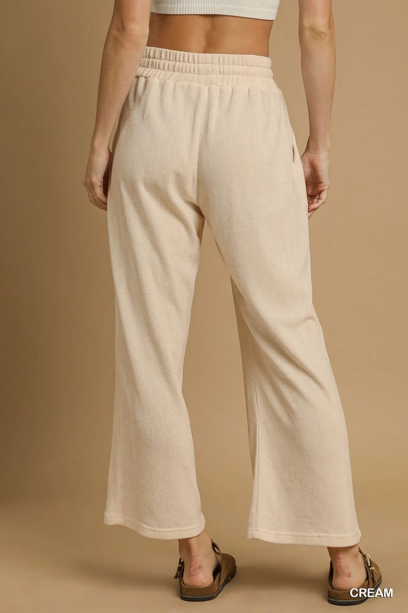 Cream Umgee drawstring wide-leg pants by Trendsi, featuring a relaxed fit and comfortable waistband, shown on a model.