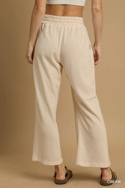 Cream Umgee drawstring wide-leg pants by Trendsi, featuring a relaxed fit and comfortable waistband, shown on a model.