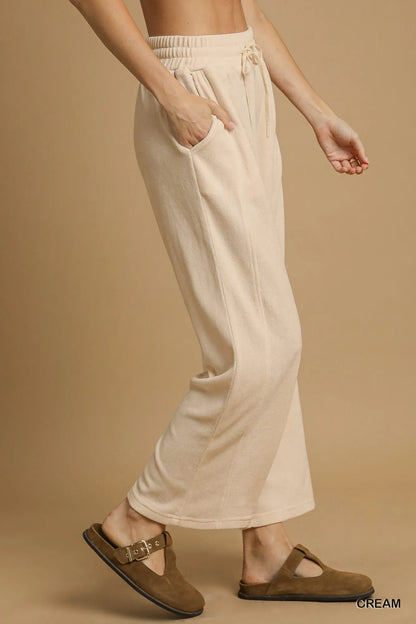 Cream Umgee drawstring wide-leg pants from Trendsi, featuring a relaxed fit and comfortable waistband, shown on a model.