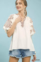 Cream Umgee embroidered sleeve top with contrast trim, featuring detailed embroidery and stylish design.