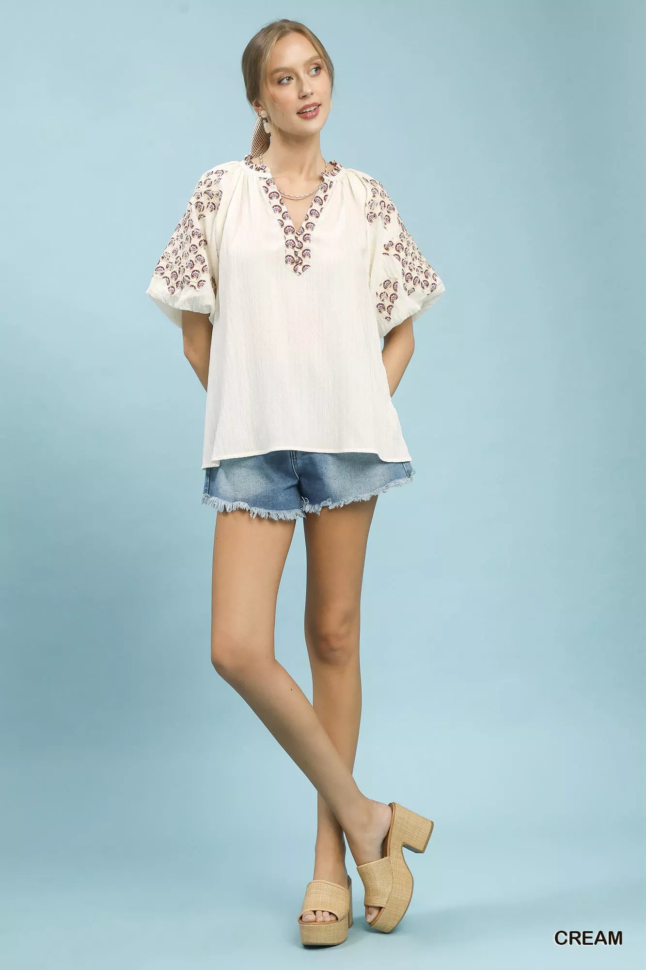 Cream Umgee embroidered sleeve contrast trim top with intricate embroidery and stylish contrast details, perfect for casual wear.