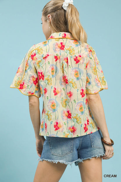Cream floral print Umgee button-down blouse with flutter sleeves, displayed on a hanger.