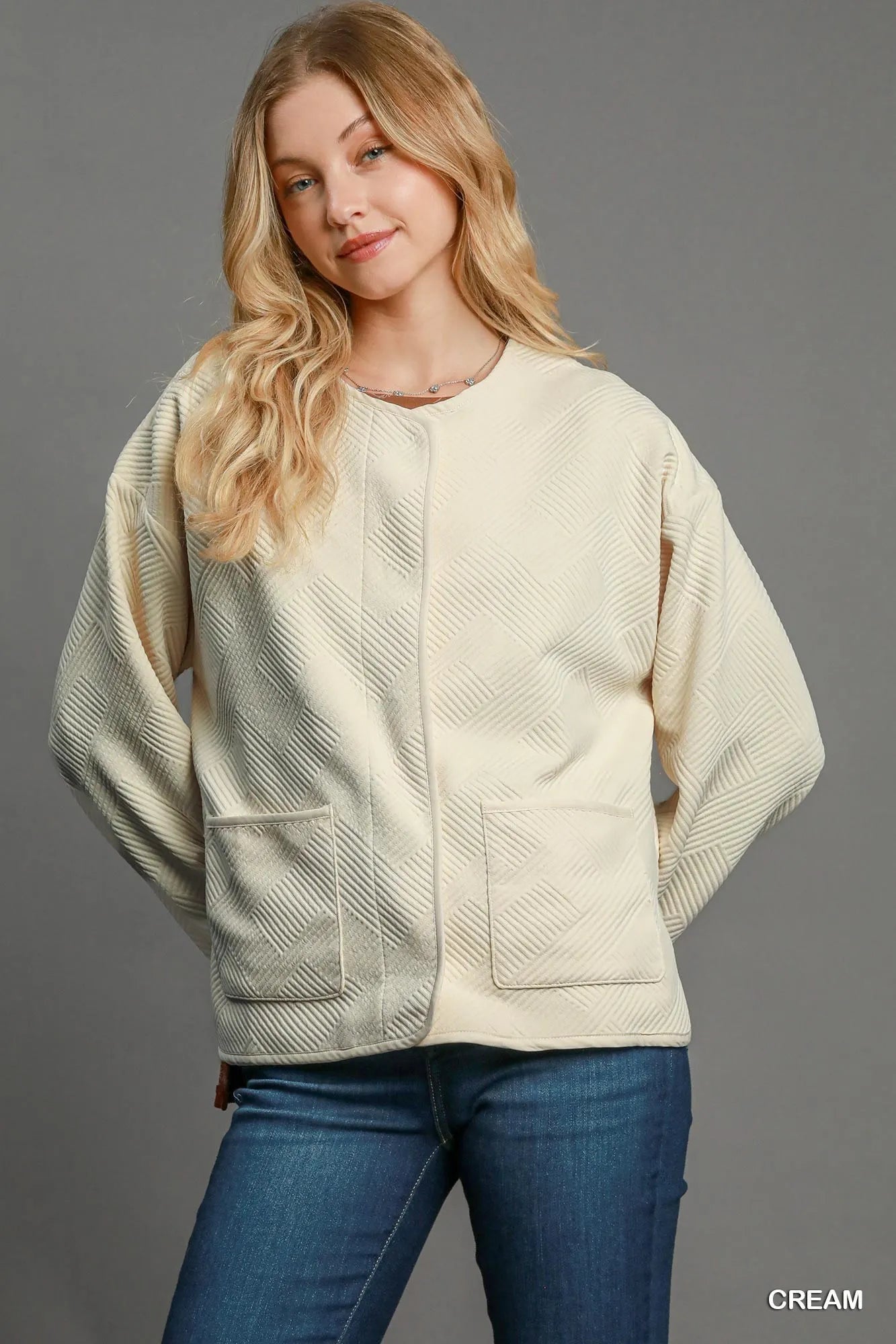 Cream Umgee textured jacquard jacket with long sleeves and a tailored fit, styled for a chic, modern look.