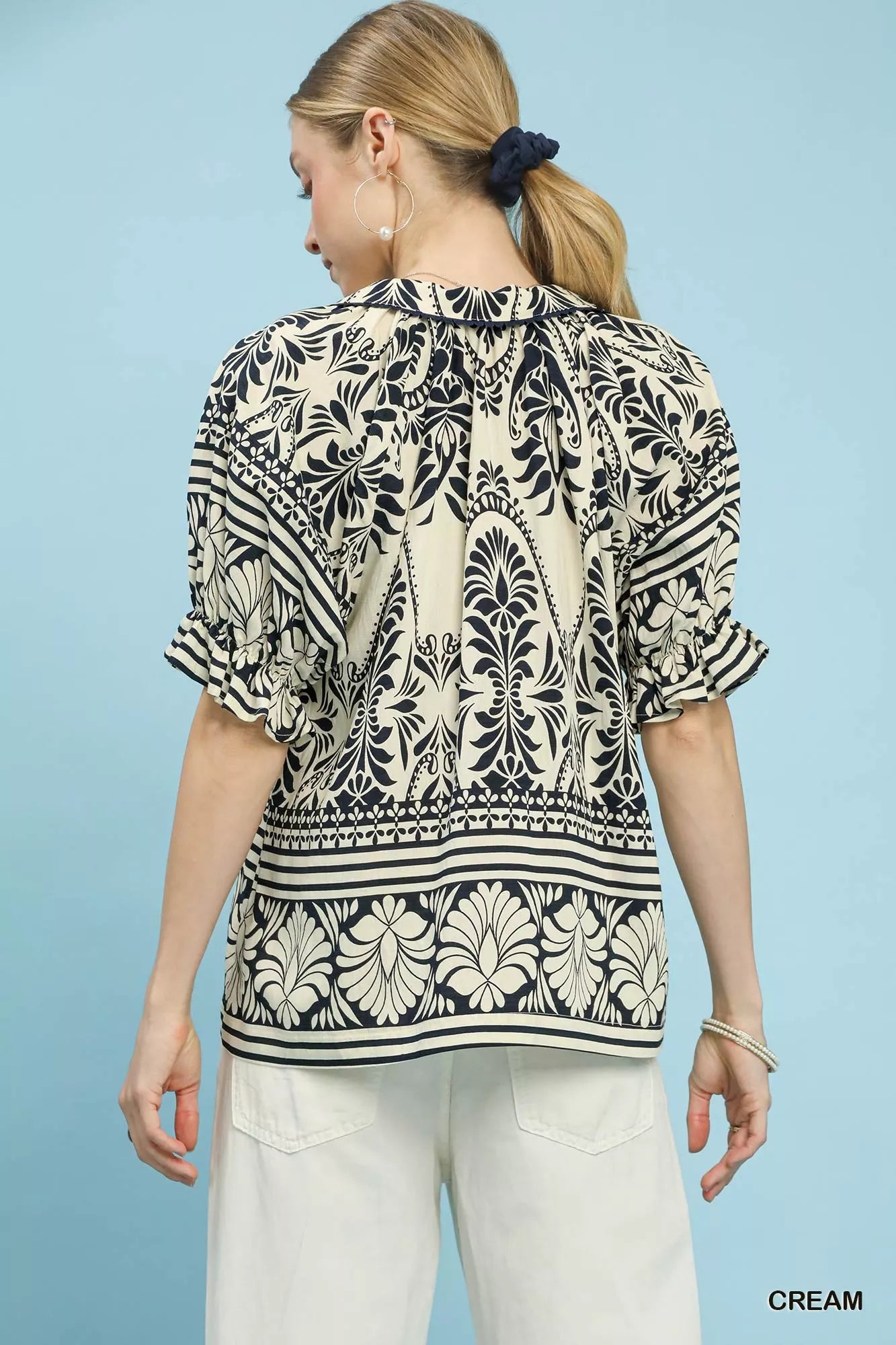 Cream Umgee two-tone border print top from Trendsi, showcasing a relaxed fit and stylish pattern on soft fabric.