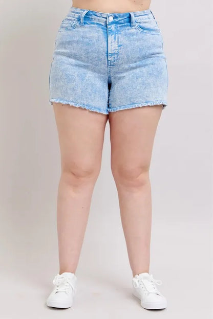 Plus size Judy Blue denim shorts with mid-rise, garment dyed fabric, in a vibrant cyan color, styled for a casual look.