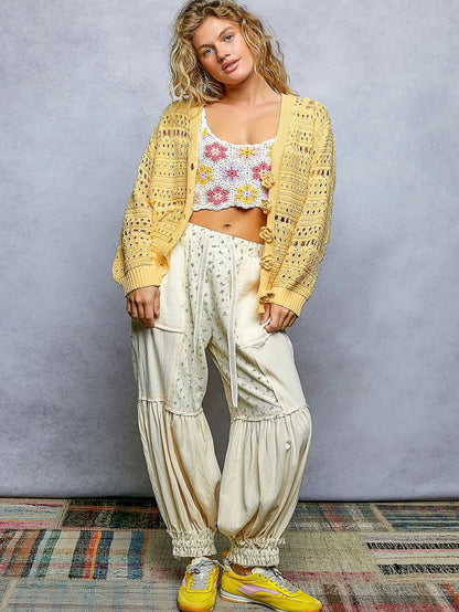 Open-knit floral button cardigan from Trendsi with a lightweight design, featuring colorful floral patterns and a relaxed fit.