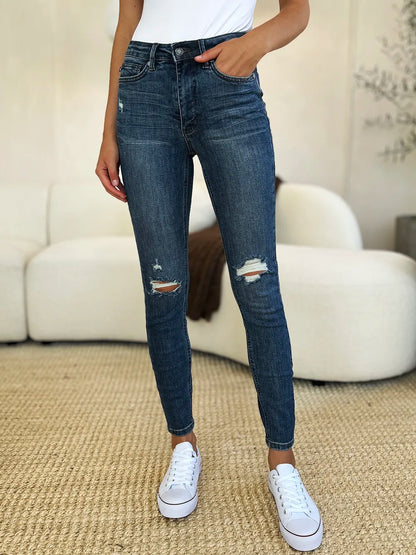 Dark Judy Blue full-size mid-waist distressed slim jeans with ripped details and a fitted silhouette.