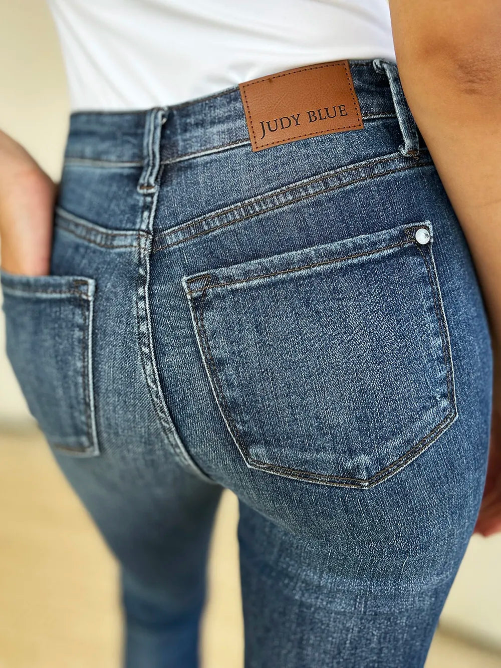 Dark Judy Blue full-size mid-waist distressed slim jeans with ripped details, styled on a model.