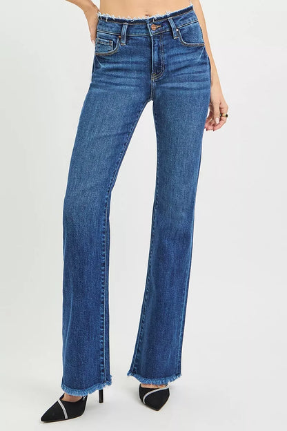 Dark blue Risen plus size bootcut jeans with mid-rise, frayed waistband, and hem detail, styled for casual wear.