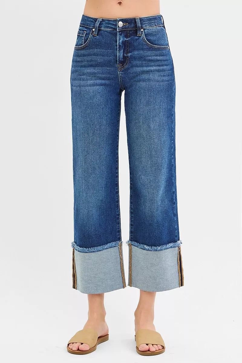 Dark wash RISEN plus size full-length mid-rise crop wide cuff jeans with a relaxed fit and cuffed hems, styled on a model.