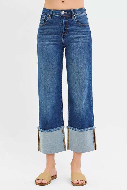 Dark wash RISEN plus size full-length mid-rise crop wide cuff jeans with a relaxed fit and cuffed hems, styled on a model.