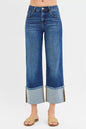 Dark wash RISEN plus size full-length mid-rise crop wide cuff jeans with a relaxed fit and cuffed hems, styled on a model.