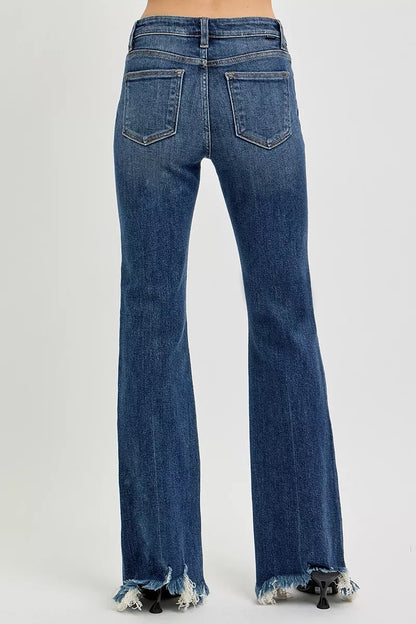 Dark wash Risen plus size mid-rise flare jeans with frayed hem, showcasing a stylish, relaxed fit and trendy denim style.
