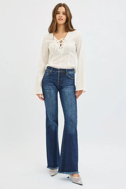 Dark wash RISEN plus size flare jeans with tummy control, mid-rise fit, designed by Trendsi, shown on a model.